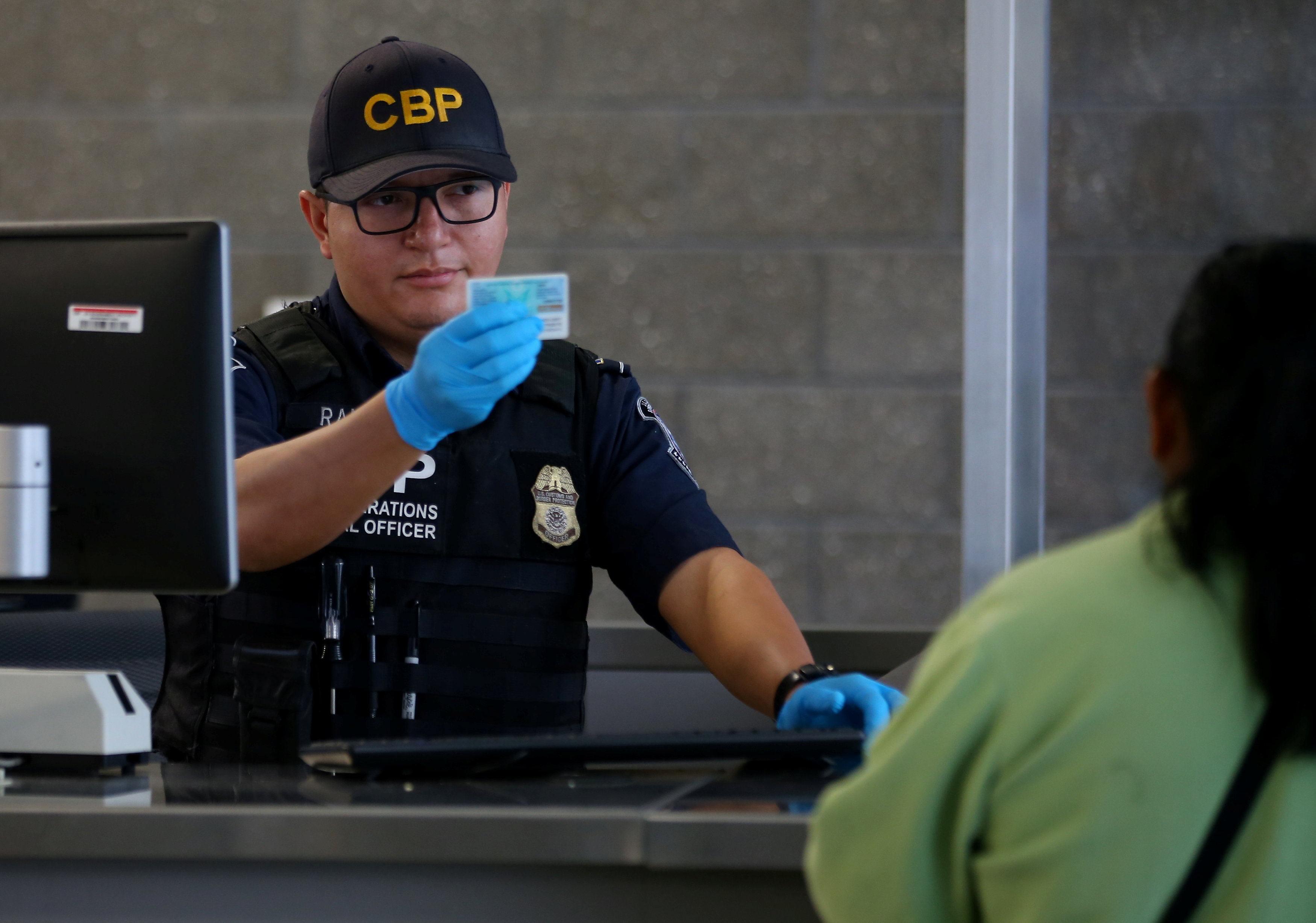 A U.S. Customs and Border Patrol officer interviews people entering the United States from Mexico at the border crossing in San Ysidro, Calif., on Oct. 14, 2016. (REUTERS/Mike Blake)