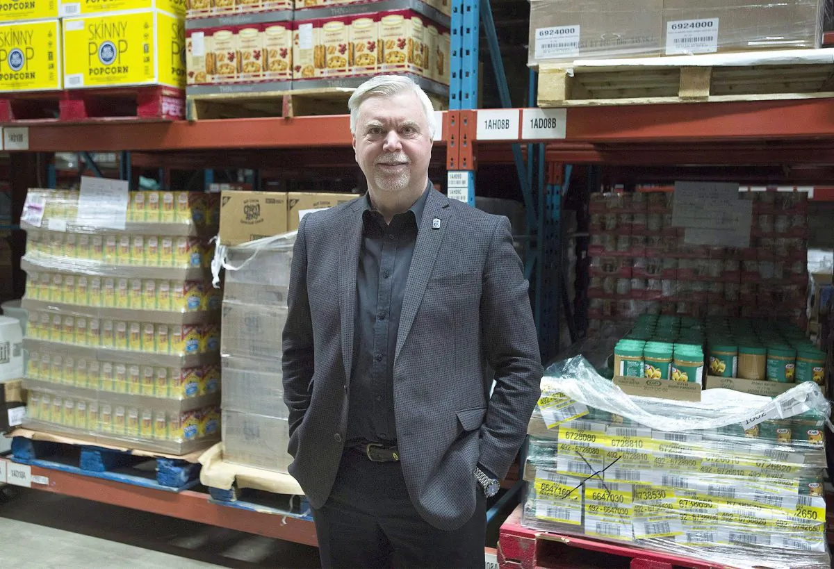 Welcome Hall Mission CEO Sam Watts stands next to pallets of food in the food bank’s warehouse in Montreal on March 14, 2017. (The Canadian Press/Graham Hughes)