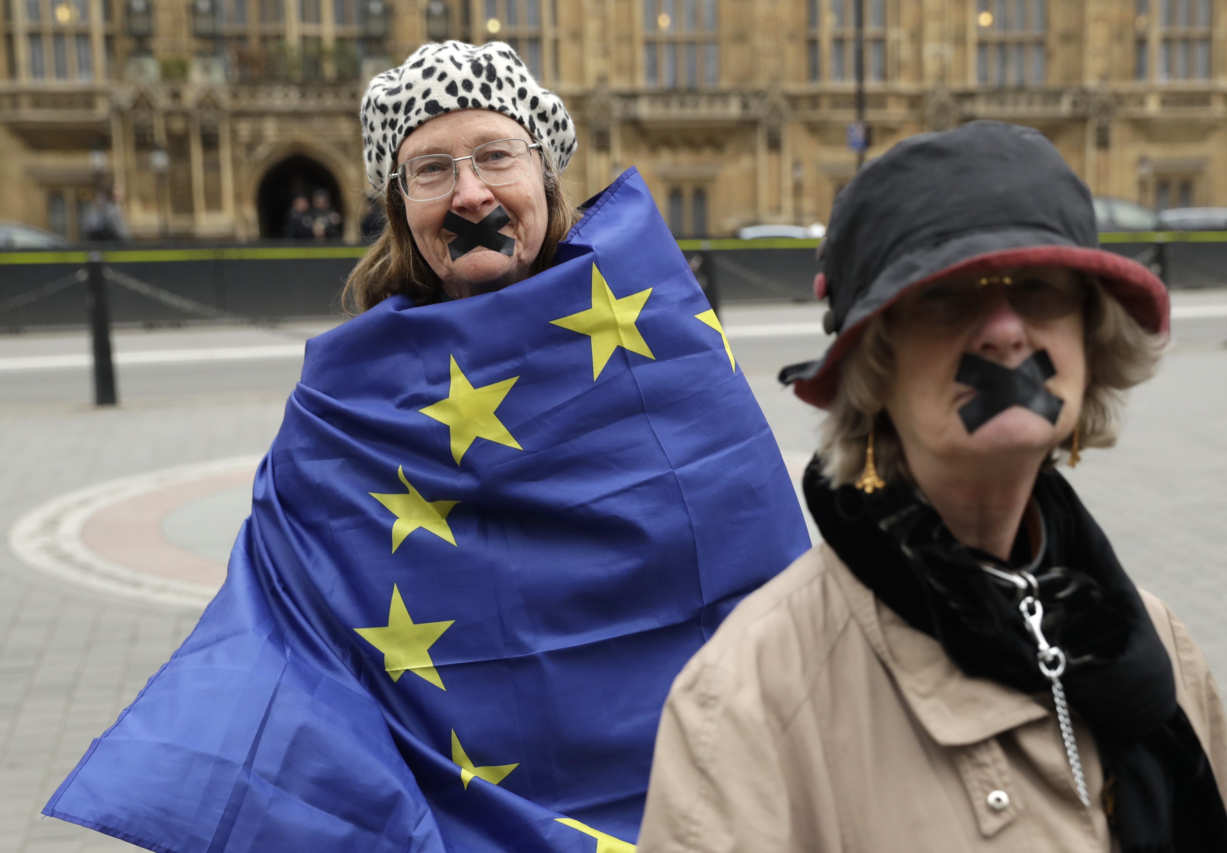 Protesters, stand outside the House of Commons in central London on March 29, 2017. (AP Photo/Matt Dunham)
