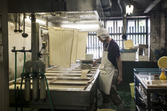 A worker making tofu at the Toyoukeya tofu shop. (Annie Wu/Epoch Times)