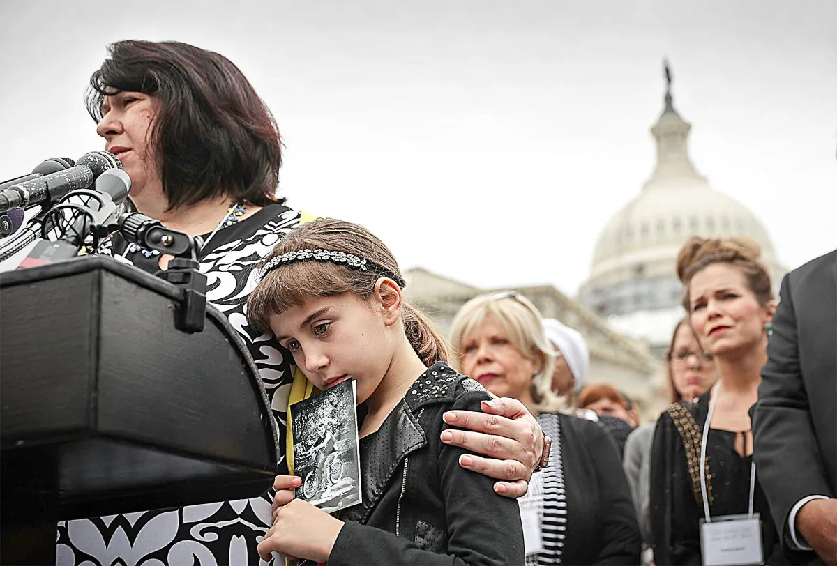 Alice D’Arpino of Mansfield, Mass., holds a picture of her brother Emmett Scannell, who died as a result of a heroin overdose, as her mother, Aimee Manzoni-D’Arpino, speaks during a news conference on the opioid epidemic on Capitol Hill on May 19, 2016. (Alex Wong/Getty Images)