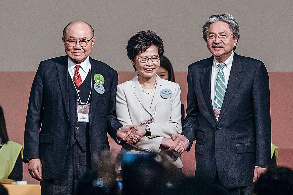 Carrie Lam (C), Hong Kong's chief executive-elect stands on stage with candidates for Hong Kong's chief executive John Tsang (R), Hong Kong's former financial secretary, and Woo Kwok-hing (L), retired judge, after the announcement of Hong Kong's chief executive election on March 26, 2017. (Anthony Kwan/Getty Images)