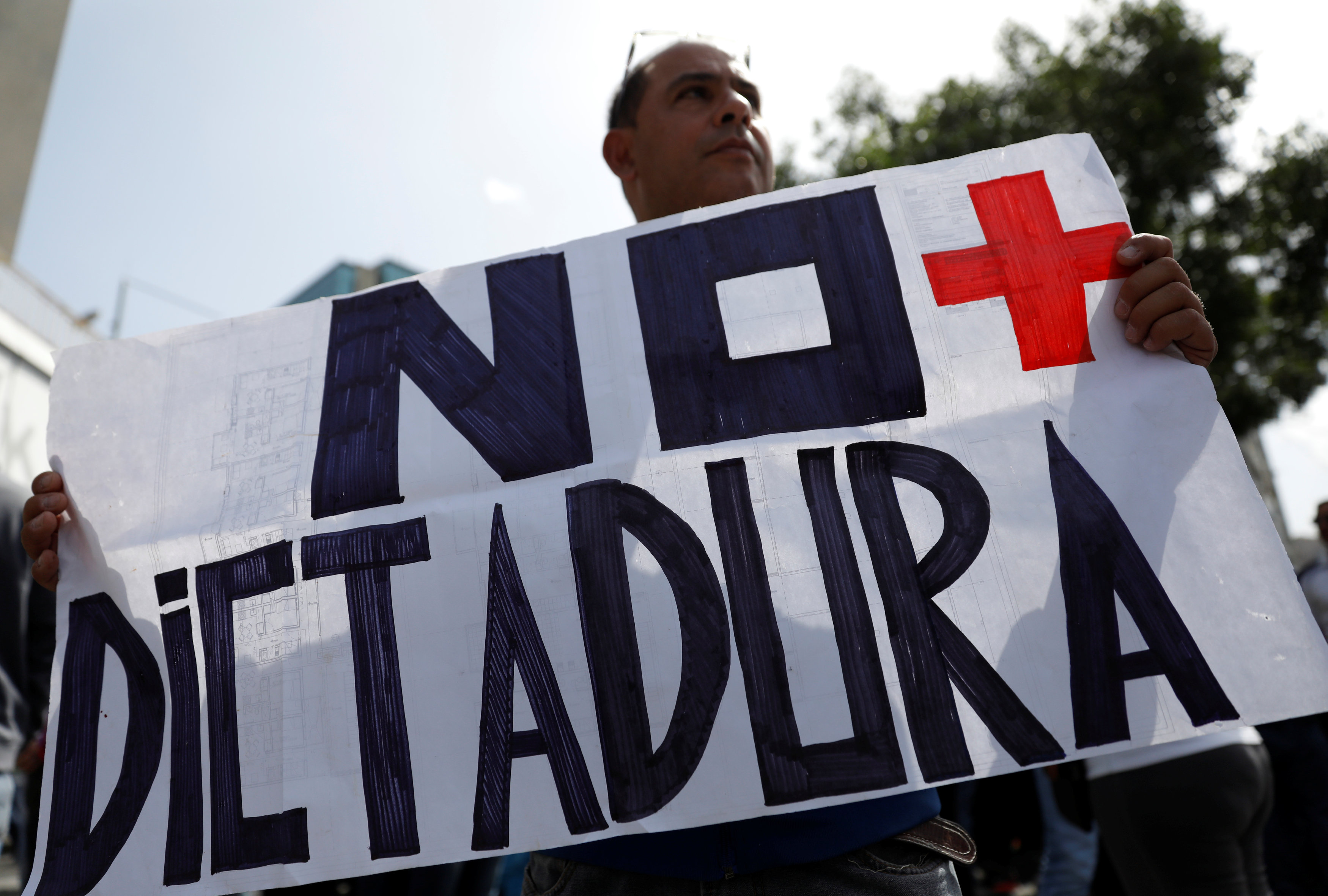 A man holds a sign reading "No more dictatorship" during an opposition rally in Caracas, Venezuela on April 4, 2017. (REUTERS/Carlos Garcia Rawlins)