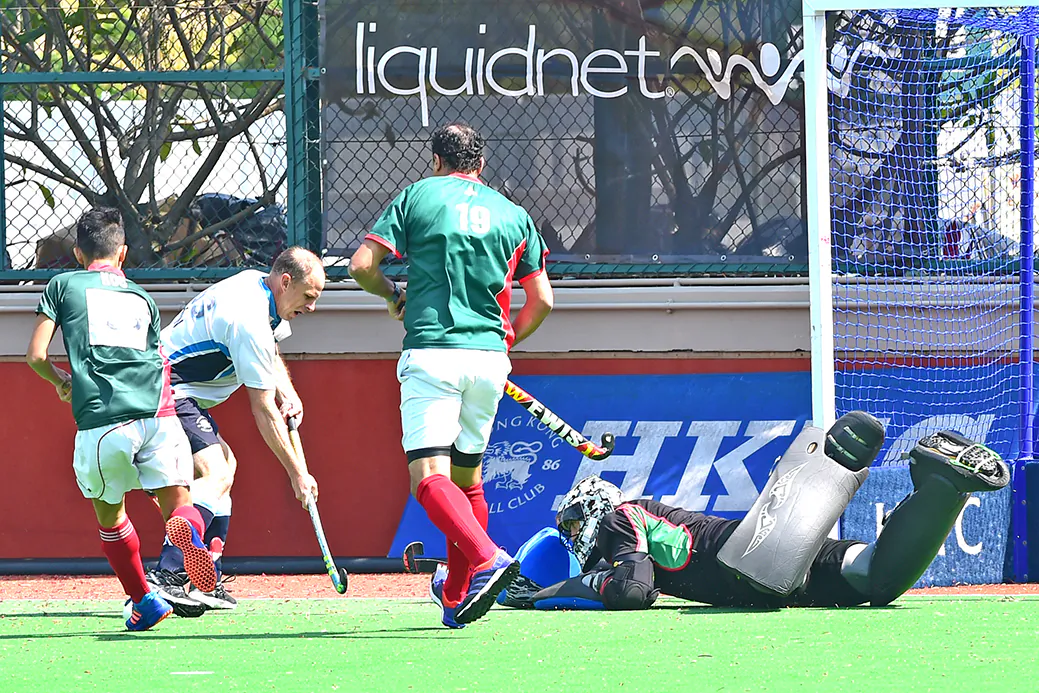 Christopher Marshall of HKFC-B tries to squeeze the ball past KCC-A goalie carefully watched by Ahmed Ewis (19) and Alexander Kwan (13). HKFC-B went on to win the match 2-0 to progress to the quarter finals of the 2016-17 Holland Cup. (Bill Cox/Epoch Times)