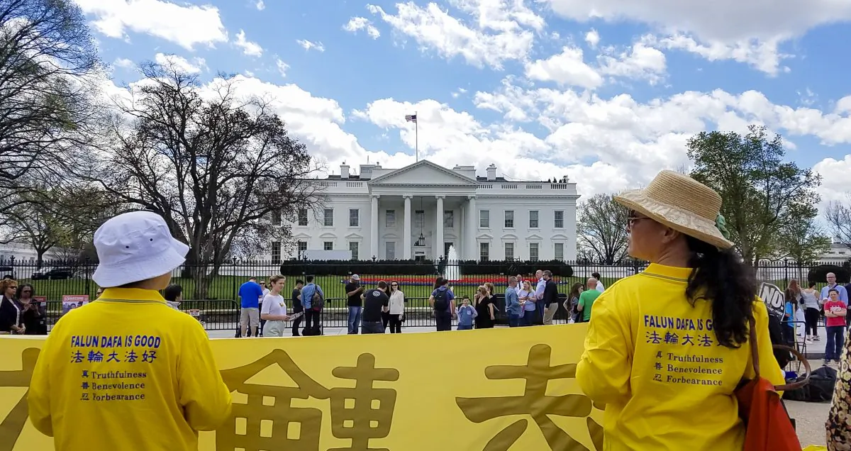 Falun Gong practitioners hold a banner opposite the White House on April 4, 2017. The practitioners gathered to ask President Trump to speak to China's head of state, Xi Jinping, about ending the persecution of Falun Gong. (Bin Xue/NTD)