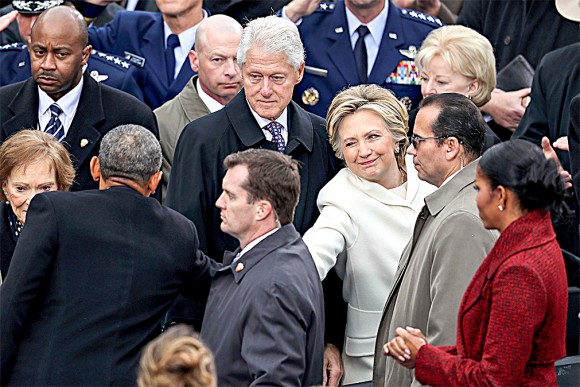 Former Democratic presidential nominee Hillary Clinton shakes hands with President Barack Obama as former president Bill Clinton looks on at the West Front of the U.S. Capitol on Jan. 20. (Joe Raedle/Getty Images)