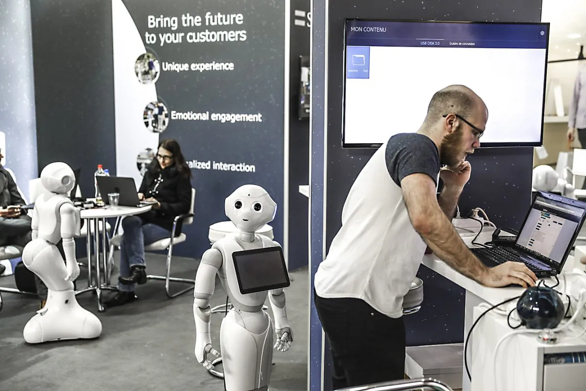 Employees and robots at the stand of SoftBank Robotics during the CeBIT fair in Hanover, Germany, on March 19, 2017. (Odd Andersen/AFP/Getty Images)