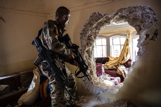 A soldier prepares to pass through a hole made between buildings during fighting in west Mosul, Iraq, on April 7, 2017. Iraqi forces backed by U.S. and British air support have entered their sixth month of fighting as they continue the battle to retake the country's second largest city from the ISIS terrorist group, which has held it since 2014. (Carl Court/Getty Images)