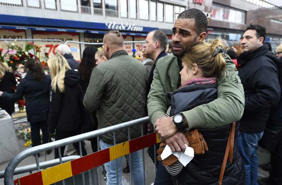 People react at a makeshift memorial near the site where a truck slammed into a crowd yesterday outside a busy department store, in central Stockholm, on April 8, 2017. (JONATHAN NACKSTRAND/AFP/Getty Images)