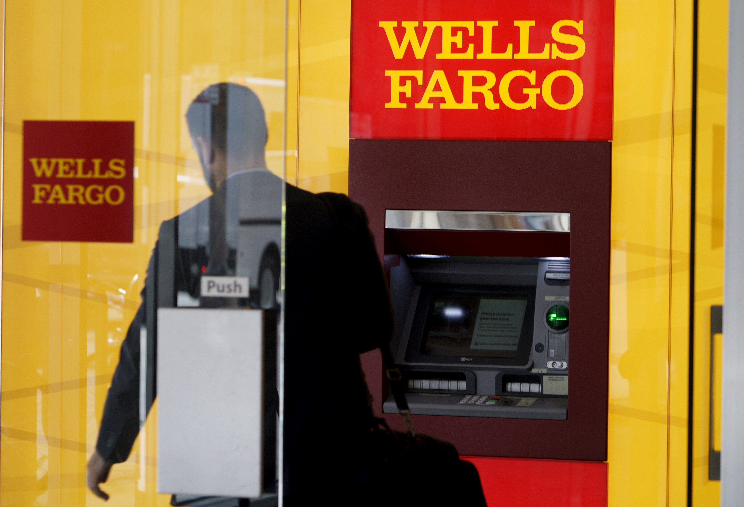 A man walks by a bank machine