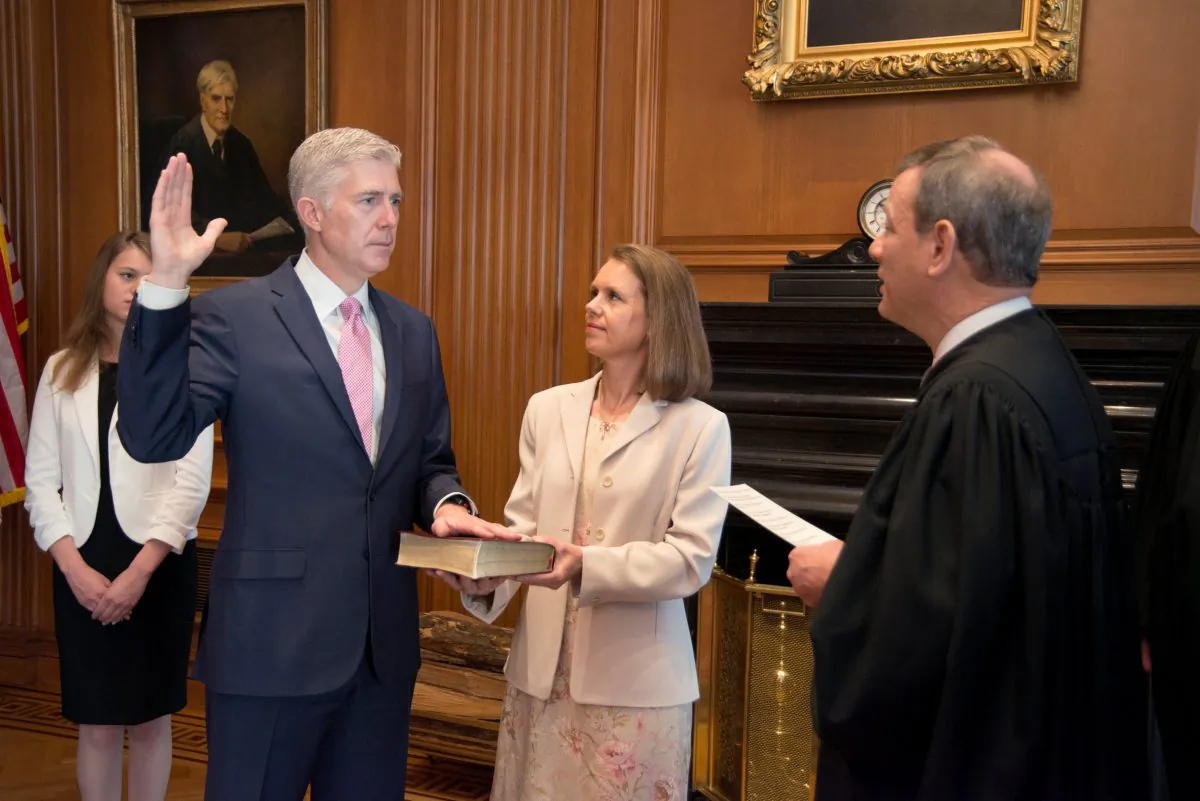 Chief Justice of the United States John Roberts (R) administers the constitutional oath to judge Neil Gorsuch, as his wife Louise Gorsuch holds the bible during a private ceremony at the Supreme Court in Washington, U.S., April 10, 2017. (REUTERS/Curator's Office; Supreme Court of the United States/Handout via Reuters)