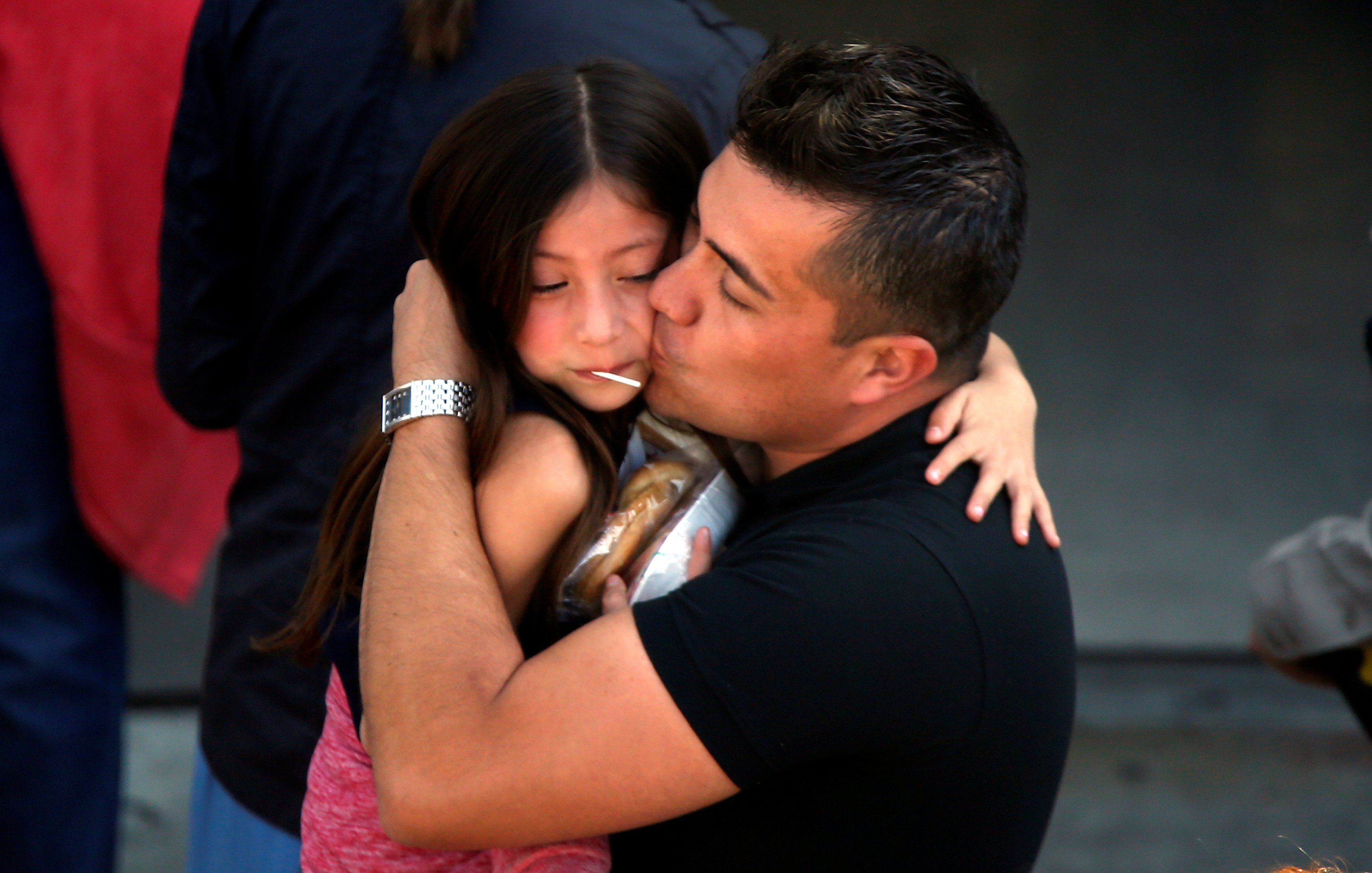 A student who was evacuated after a shooting at North Park Elementary School is embraced after groups of them were reunited with parents waiting at a high school in San Bernardino, Calif. (REUTERS/Mario Anzuoni)