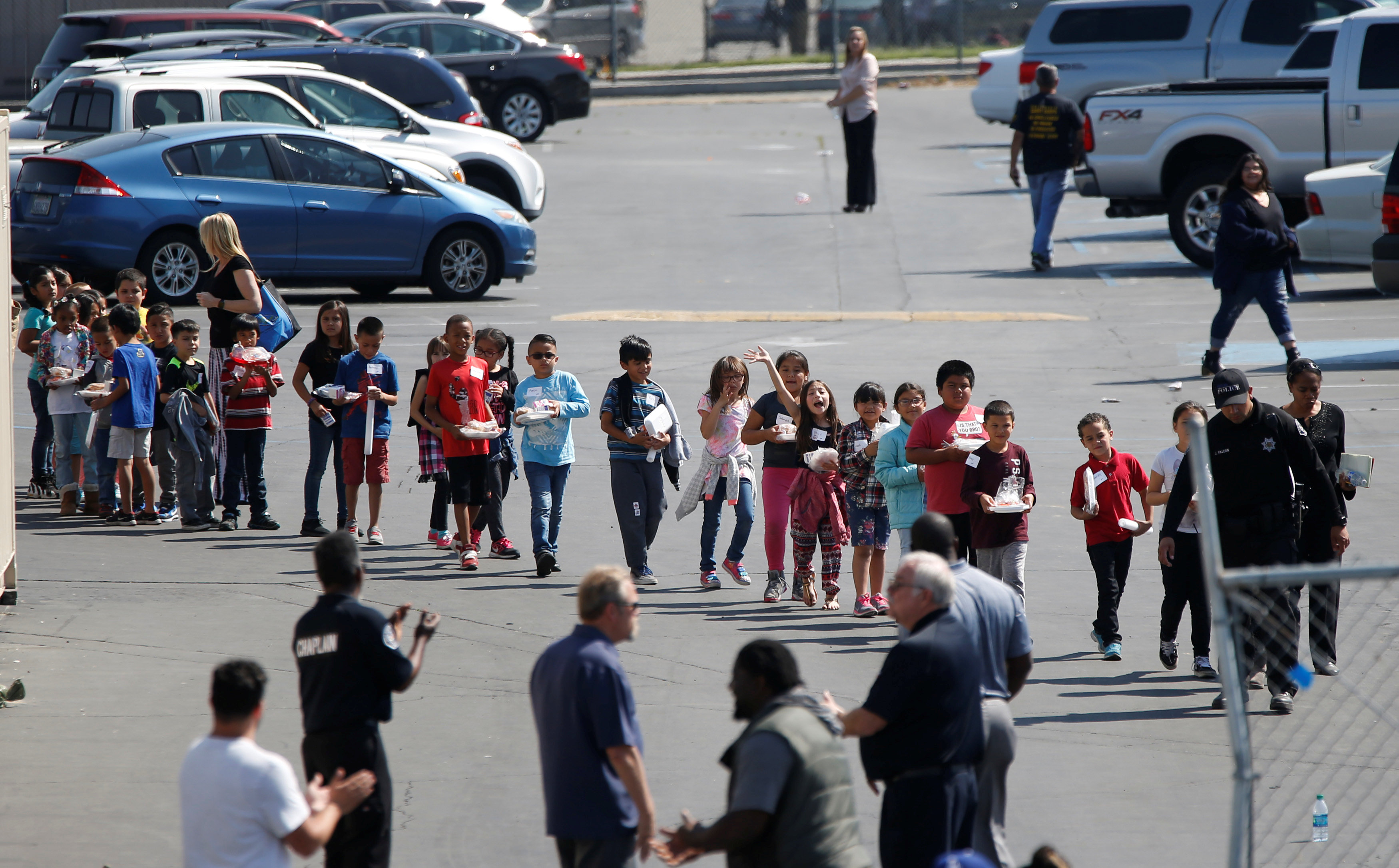 Students who were evacuated after a shooting at North Park Elementary School walk past well-wishers to be reunited with their waiting parents at a high school in San Bernardino, Calif., on April 10, 2017. (REUTERS/Mario Anzuoni)