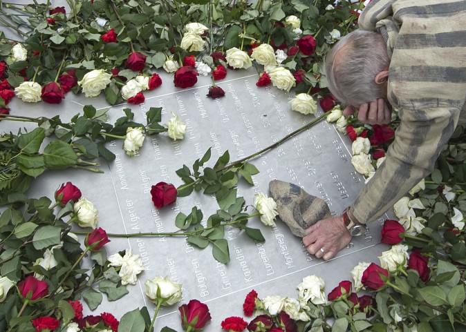 Nazi concentration camp survivor Alexander Bytschok of Kiev, Ukraine, mourns on a metal plaque during ceremonies commemorating the 72nd anniversary of the liberation of the former Nazi concentration camp Buchenwald near Weimar, Germany, on April 11, 2017. (AP Photo/Jens Meyer)
