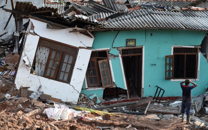  A Sri Lankan resident walks through damaged homes at the site of a collapsed garbage dump in Colombo on April 16. Hopes of finding anyone alive under a collapsed mountain of garbage in Sri Lanka's capital faded as the death toll reached 23 with another six reported missing, police said. (ISHARA S. KODIKARA/AFP/Getty Images)