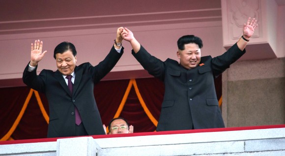 North Korea's leader Kim Jong-Un (R) and Chinese Politburo standing committee member Liu Yunshan (L) wave from a balcony towards participants of a mass military parade at Kim Il-Sung square in Pyongyang on October 10, 2015. North Korea was marking the 70th anniversary of its ruling Workers' Party. (ED JONES/AFP/Getty Images)