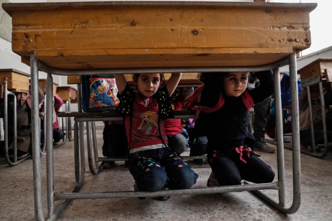 Schoolchildren learn how to protect themselves in case of a bombardment during a war safety awareness class as part of a campaign conducted by the Syrian civil defence, known as The White Helmets, in the rebel-held area of Harasta, on the northeastern outskirts of the capital Damascus, on May 2. (SAMEER AL-DOUMY/AFP/Getty Images)