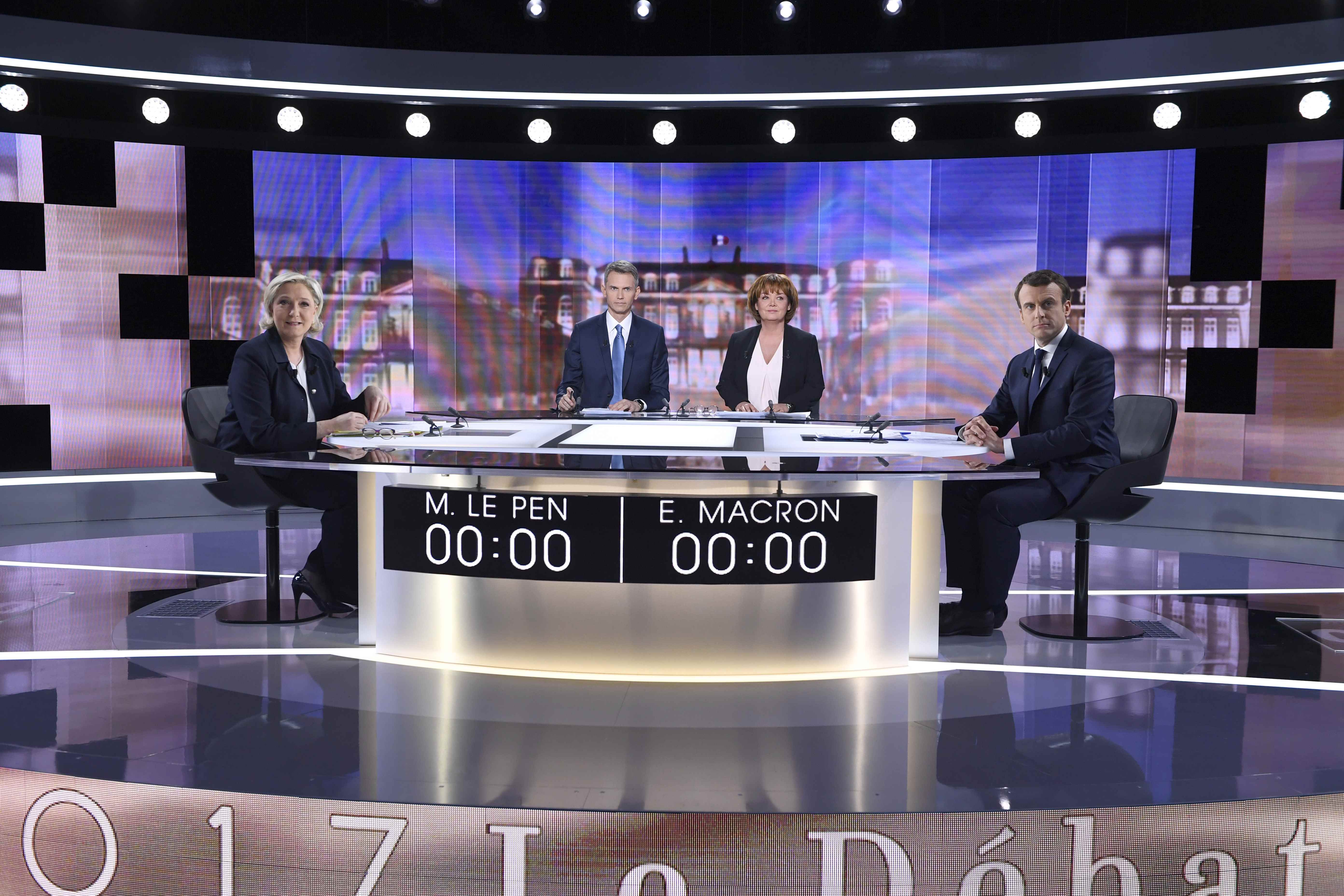(L-R) French presidential election candidate for the Front National (FN) party, Marine Le Pen, French journalist Christophe Jakubyszyn, French journalist Nathalie Saint-Cricq and French presidential election candidate for the En Marche ! or Onwards ! movement, Emmanuel Macron prior to the start of a live broadcast face-to-face debate in television studios of French public national television channel France 2, and French private channel TF1 in La Plaine-Saint-Denis, Paris, France on May 3, 2017. (REUTERS/Eric Feferberg/Pool)