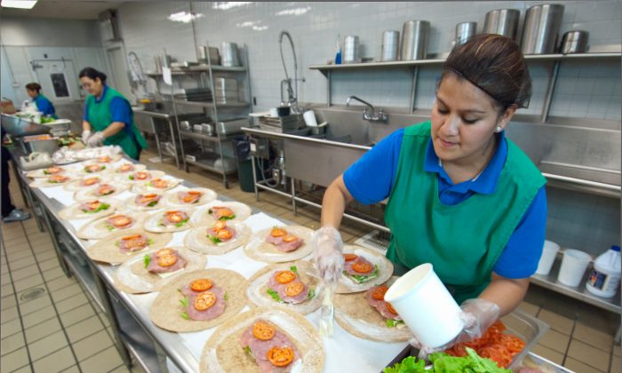 Candy Flores (R) of Arlington Food Services prepares ham and cheese wraps for the National School Lunch Program in the kitchen at Washington-Lee High School in Arlington, Va., Oct. 19, 2011. (U.S. Department of Agriculture)
