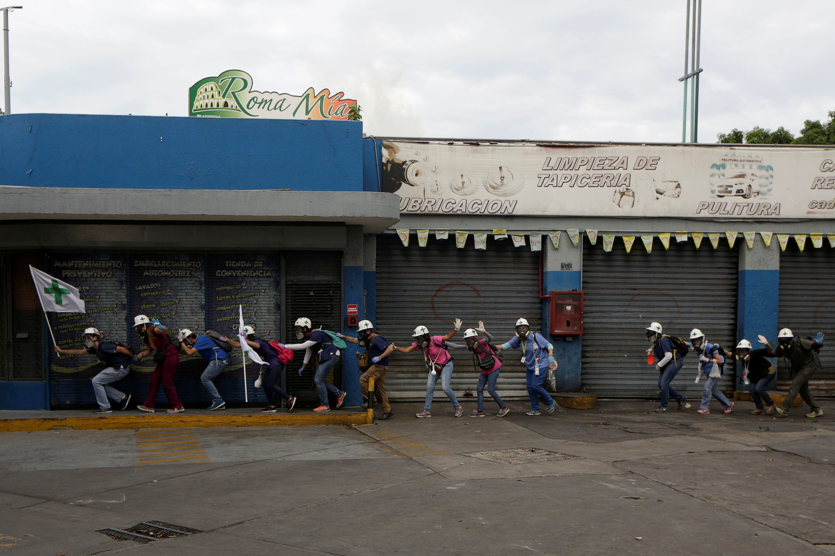 Volunteers, members of a primary care response team, walk together as demonstrators clash with police during a rally against Venezuela's President Nicolas Maduro in Caracas, Venezuela. (REUTERS/Marco Bello)