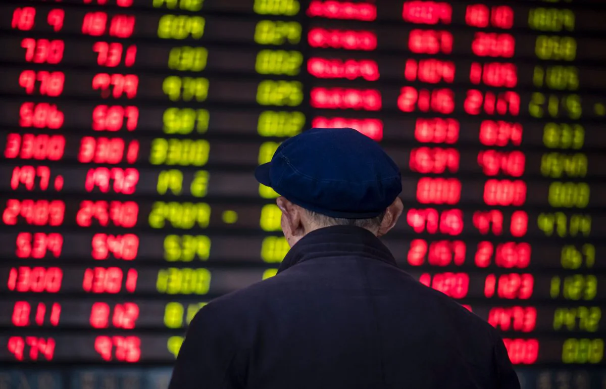 An investor looks at an electronic board showing stock information at a brokerage house in Shanghai on March 16, 2017. (Johannes Eisele/AFP/Getty Images)