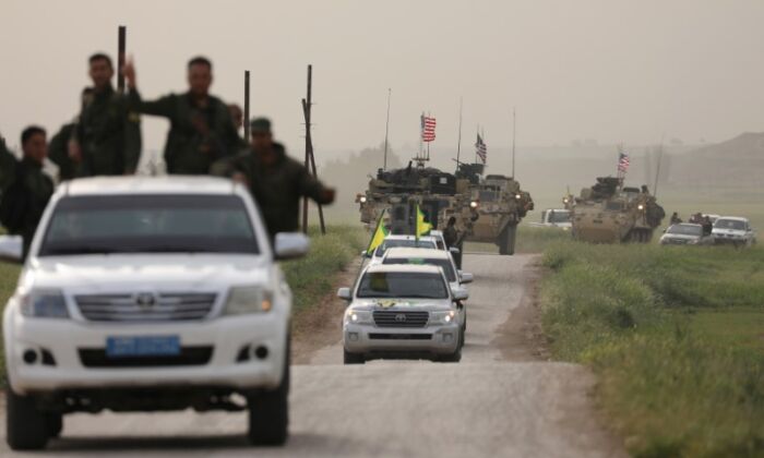 Kurdish fighters from the People's Protection Units (YPG) head a convoy of U.S.  military vehicles in the town of Darbasiya next to the Turkish border, Syria April 28, 2017. (Rodi Said/Reuters)