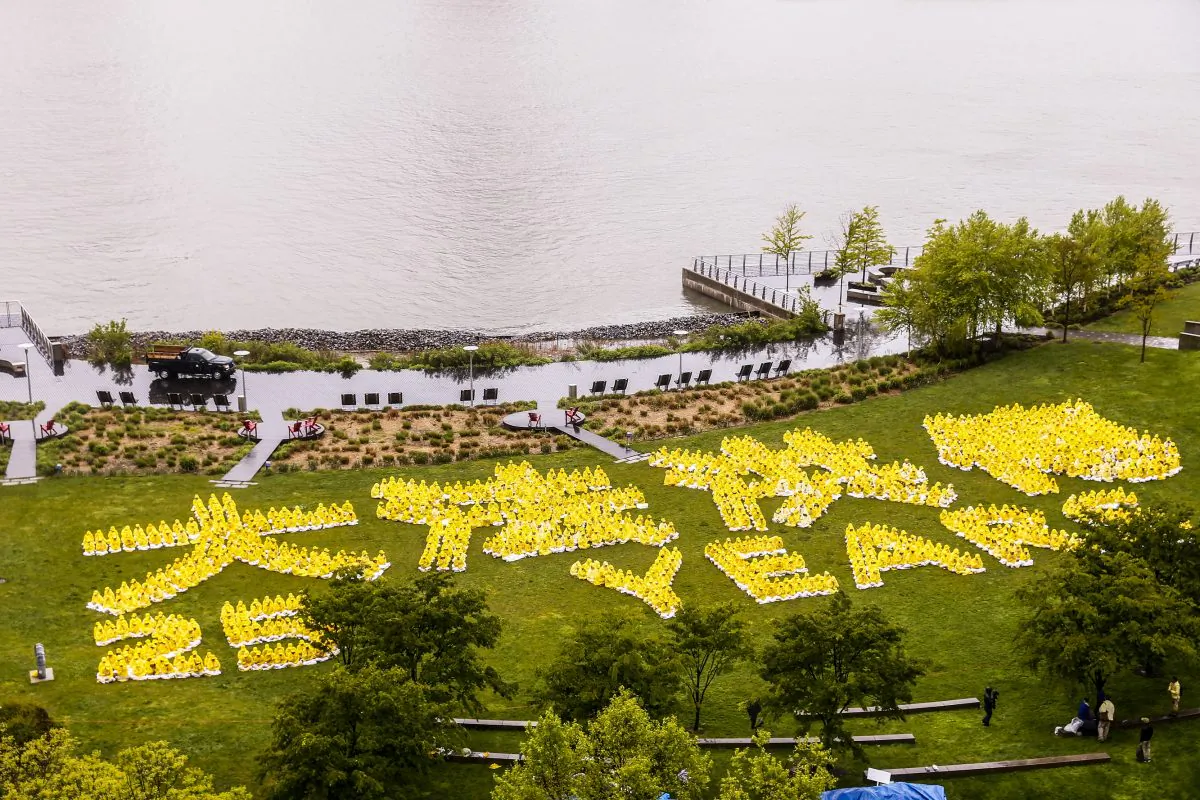 1,300 falun Gong practitioners in Gantry Park, New York, form Chinese and English words saying "25 years of spreading Dafa" on May 13, 2017. (The Epoch Times)