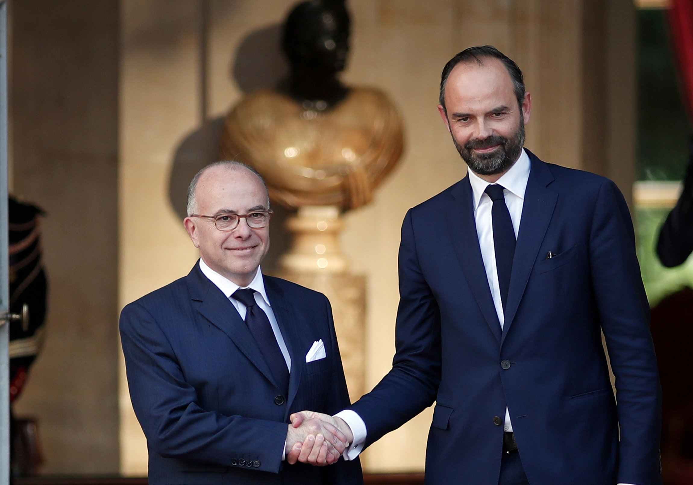 Newly-appointed French Prime Minister Edouard Philippe (R) is greeted by his predecessor Bernard Cazeneuve (L) during a handover ceremony at the Hotel Matignon, in Paris, France on May 15, 2017. (REUTERS/Benoit Tessier)