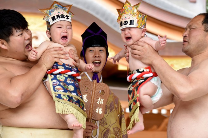 Sumo wrestlers hold up crying babies in front of a referee (C) during a 'Baby-cry Sumo' event in Kanagawa prefecture, Japan, on May 14, 2017. Some 150 babies aged under two, took part in the annual baby crying contest in the Shinto shrine in Sagamihara. Japanese parents believe that sumo wrestlers can help make babies cry out a wish to grow up in good health. (TORU YAMANAKA/AFP/Getty Images)