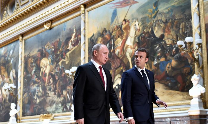 French President Emmanuel Macron (R) speaks to Russian President Vladimir Putin (L) in the Galerie des Batailles (Gallery of Battles) as they arrive for a joint press conference in Versailles, France, on May 29, 2017.  (Stephane De Sakutin/Pool/Reuters)