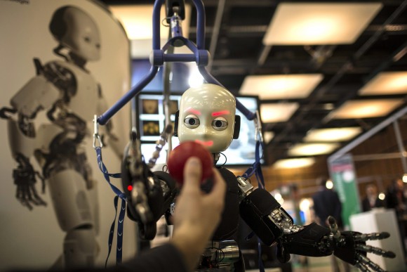 The iCub robot tries to catch a ball during the Innorobo European summit in this 2013 file photo. The event is dedicated to the service robotics industry in Lyon, France. Robots and artificial intelligence threaten low-skilled manufacturing jobs but open opportunities for those capable of creating and programming them. (AP Photo/Laurent Cipriani, File)