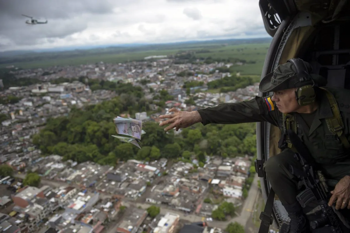 Jose Mendoza, head of Colombia's anti-narcotics police, throws pamphlets offering rewards for information leading to the capture of members of the Gulf Clan cartel, as part of the Agamemnon anti-drug trafficking operation in Apartado, Colombia, on May 31, 2017. (Raul Arboleda /AFP/Getty Images)