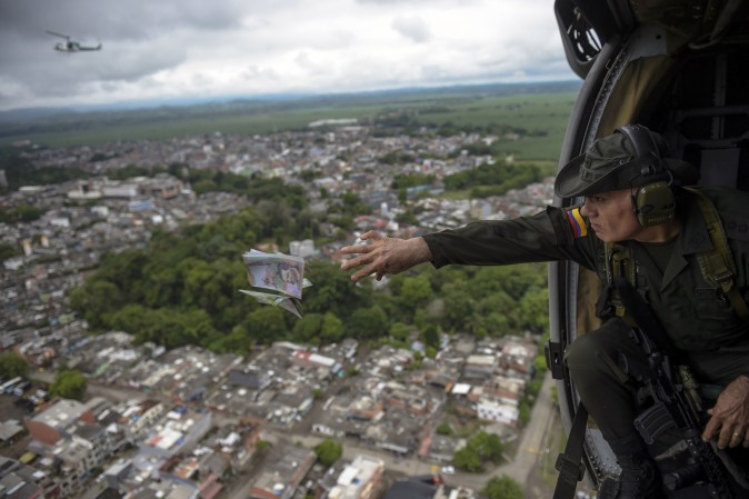 Jose Mendoza, head of Colombia's anti-narcotics police, throws pamphlets offering rewards for information leading to the capture of members of the Gulf Clan cartel, as part of the Agamemnon anti-drug trafficking operation in Apartado, Colombia, on May 31, 2017. (RAUL ARBOLEDA/AFP/Getty Images)