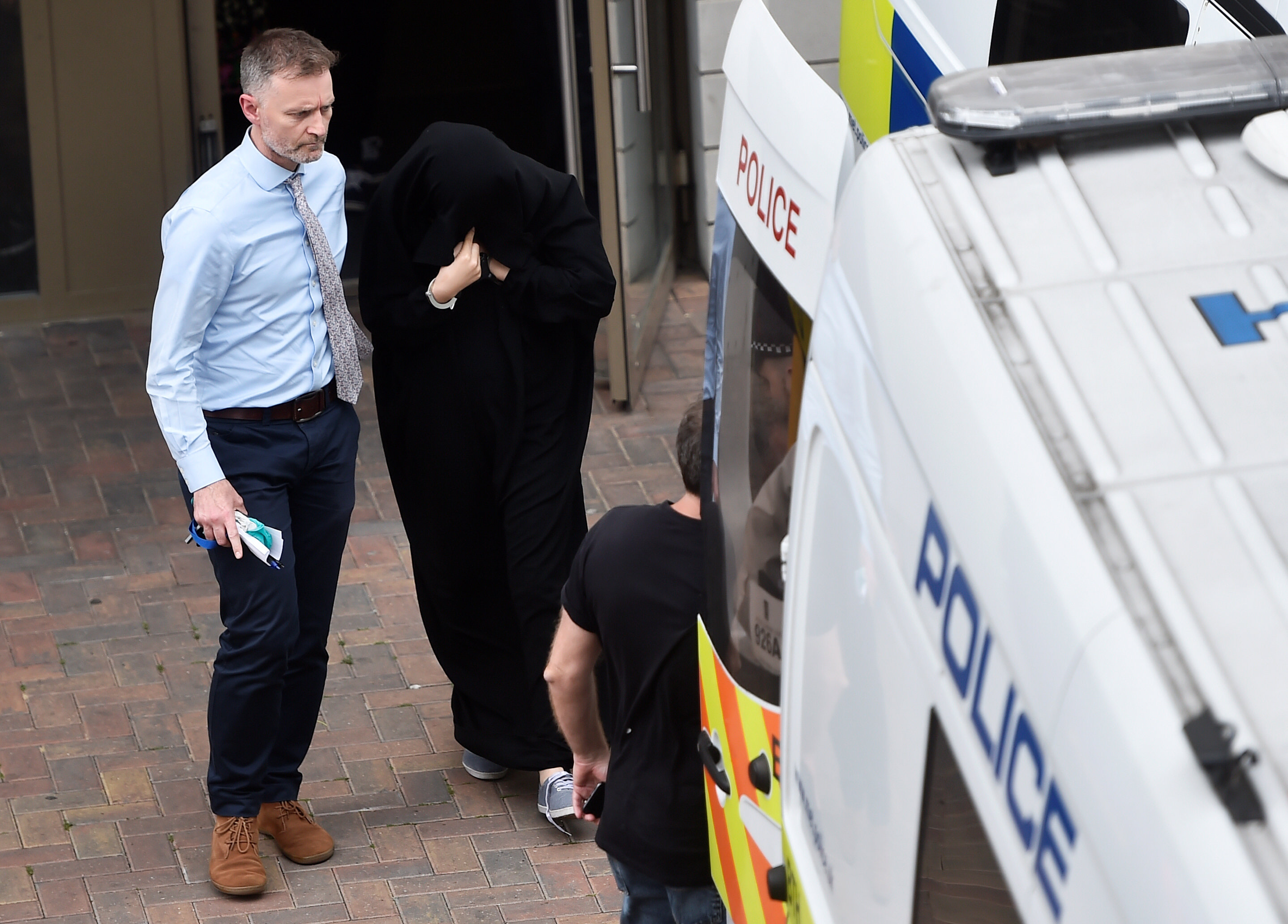 Police officers escort a woman to a police van after raiding a block of flats in Barking, east London, Britain on June 4, 2017. (REUTERS/Hannah McKay)