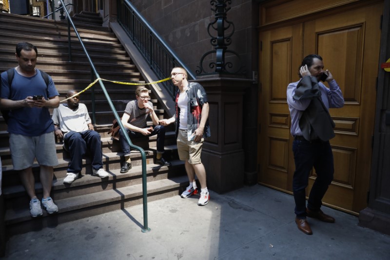 People speak on their cell phones near a blocked off area after a speeding vehicle struck pedestrians in Times Square in New York City on May 18, 2017. (REUTERS/Brendan Mcdermid)