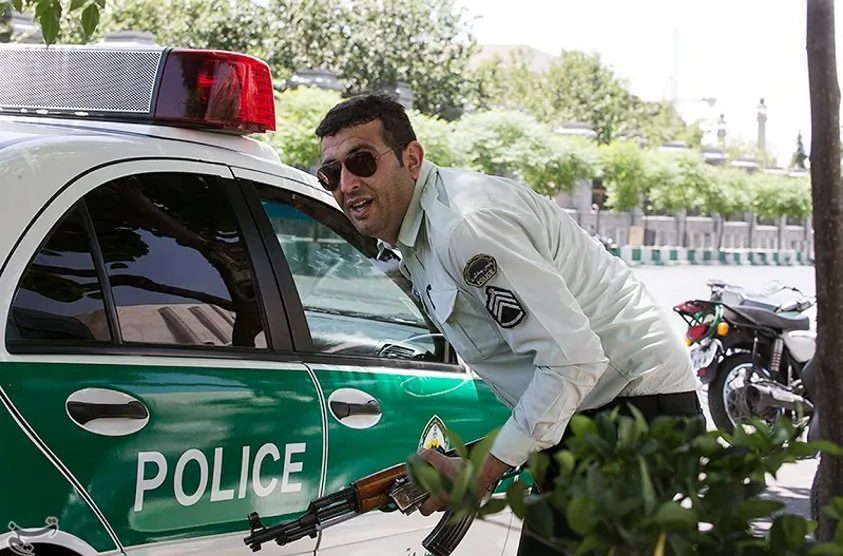 An Iranian policeman takes cover during an attack on the Iranian parliament in central Tehran, Iran on June 7, 2017. (Tasnim News Agency/Handout via REUTERS)