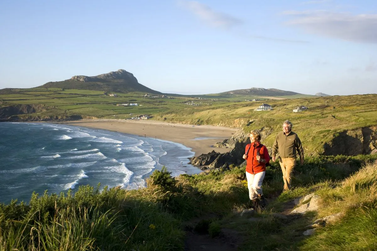 A couple walking the Coast Path overlooking Whitesands Bay on the Pembrokeshire coast in southwest Wales. (VisitBritain/Rod Edwards)