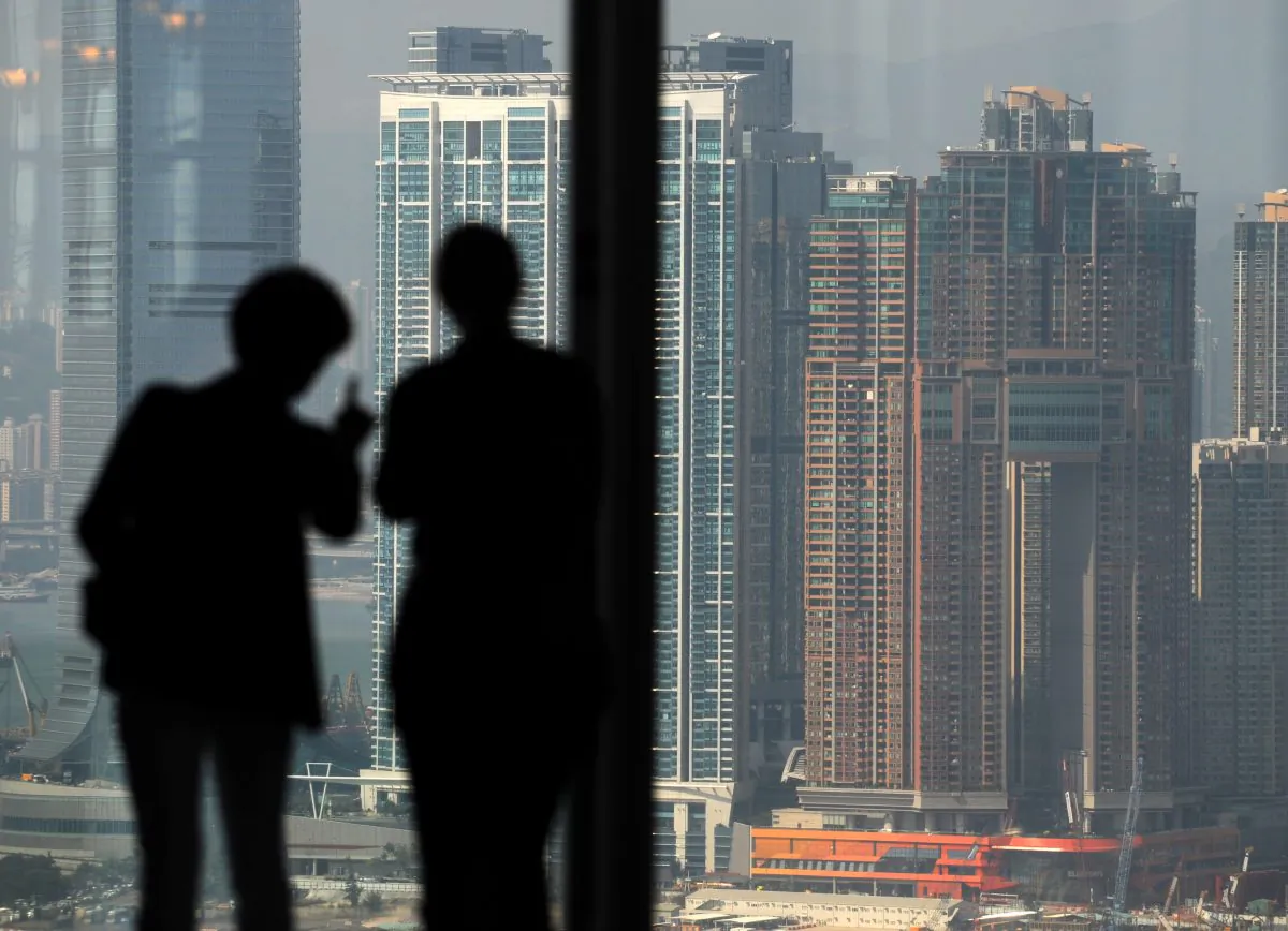 Two people look towards high-rise buildings in Kowloon, Hong Kong, in a file photo. The Hong Kong Monetary Authority and Beijing have agreed to launch a cross-border bond connect, granting foreign investors access to the Chinese onshore bond market. (Antony Dickson/AFP/Getty Images)