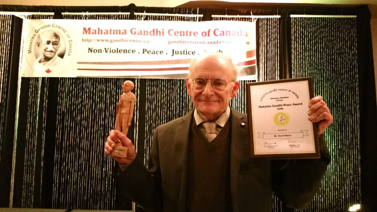 Canadian human rights lawyer David Matas holds up his Mahatma Gandhi Peace Award on June 8, 2017 at the Mahatma Gandhi Peace Awards Dinner Gala in Winnipeg. (The Epoch Times)