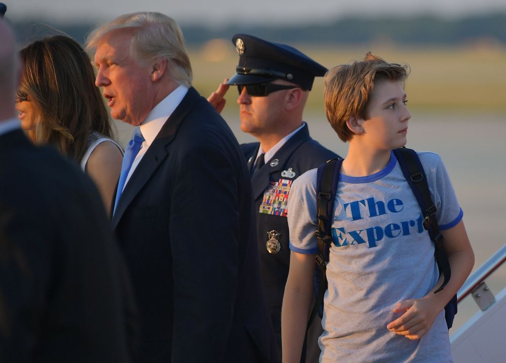 Barron Trump (R), the son of US President Donald Trump (2L) and First Lady Melania Trump (L) look back at Air Force One upon arrival at Andrews Air Force Base in Maryland on June 11, 2017.  Trump is returning to Washington, DC after spending the weekend at this Bedminster, New Jersey golf club. / AFP PHOTO / MANDEL NGAN        (Photo credit should read MANDEL NGAN/AFP/Getty Images)