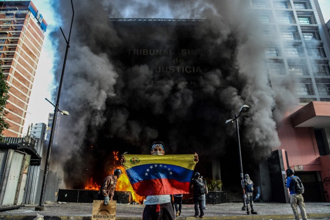 Anti-government demonstrators attack the administration headquarters of the Supreme Court of Justice as part of protests against President Nicolas Maduro in Caracas, Venezuela, on June 12, 2017. With Venezuelans suffering from high inflation, food shortages and soaring crime rates, plus a deepening corruption scandal, the Venezuelan opposition has mounted near-daily anti-government protests since April 1. (FEDERICO PARRA/AFP/Getty Images) 