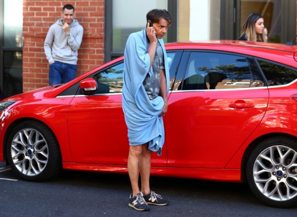 A man wrapped in a towel speaks on a cell phone near the scene of a fire in a tower block, in West London, Britain on June 14, 2017. (REUTERS/Neil Hall)