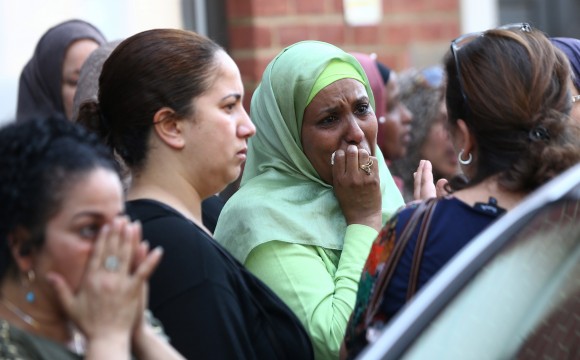 People react near a tower block severely damaged by a serious fire, in north Kensington, West London, Britain June 14, 2017. REUTERS/Neil Hall
