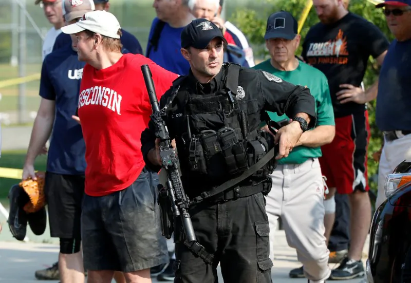 A U.S. Capitol police SWAT team officer escorts members of Congress and congressional staff from the scene after a gunman opened fire on Republican members of Congress during a baseball practice near Washington in Alexandria, Virginia, on June 14, 2017. (Joshua Roberts/REUTERS)