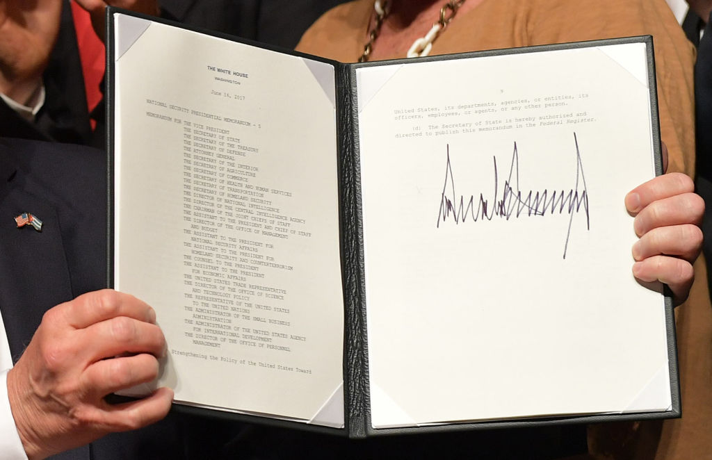 US President Donald Trump holds up a memorandum he signed on the US/ Cuba policy after he spoke at the Manuel Artime Theater in Miami, Fla., on June 16, 2017. (MANDEL NGAN/AFP/Getty Images)