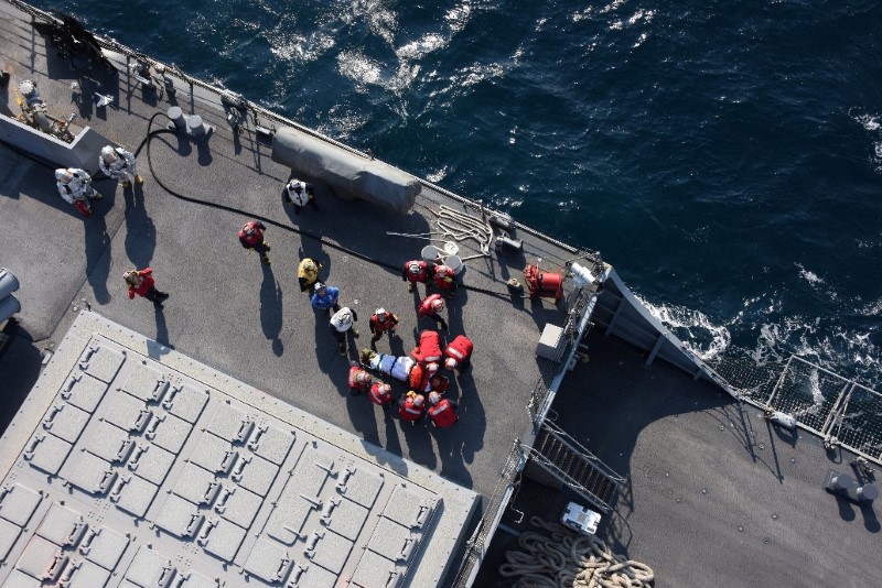 An injured crew member (C) of the Arleigh Burke-class guided-missile destroyer USS Fitzgerald, damaged after colliding with a Philippine-flagged merchant vessel, is carried on a stretcher on the destroyer off Shimoda, Japan June 17, 2017.  Japan Maritime Self-Defense Force/Handout via REUTERS