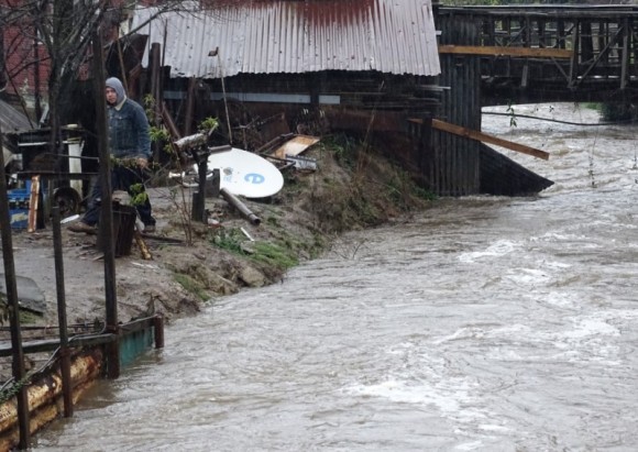 A man walks beside a flooded street due to torrential rains causing a river to overflow, in Curanilahue city, south of Chile,  June 16, 2017. (Reuters/Manuel Araneda)