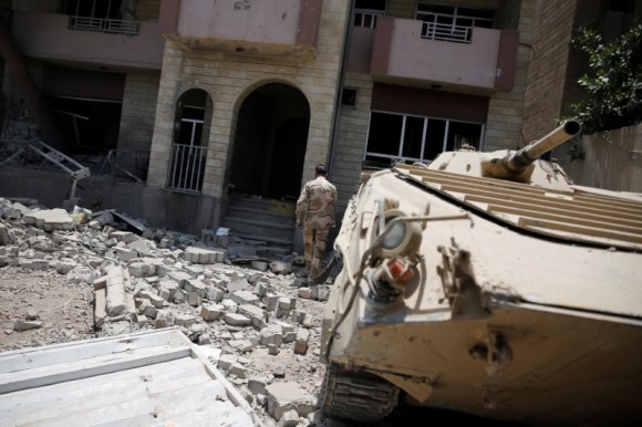 A member of the Iraqi Army's 9th Armoured Division walks among debris at the yard of a destroyed building at the frontline in western Mosul, Iraq June 17, 2017. REUTERS/Alkis Konstantinidis