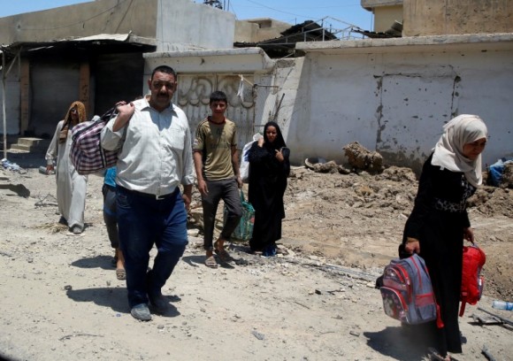 Displaced civilians carry their belongings after fleeing their homes due to fighting between the Iraqi forces and Islamic State militants in the Old City in western Mosul, Iraq June 18, 2017. (Reuters/Erik De Castro)
