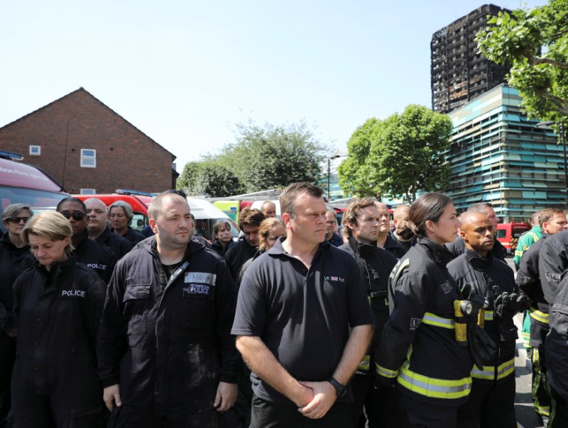 Members of the emergency services attend a minute's silence for the victims of the Grenfell Tower fire near the site of the blaze in North Kensington, London, Britain on June 19, 2017. (REUTERS/Marko Djurica)